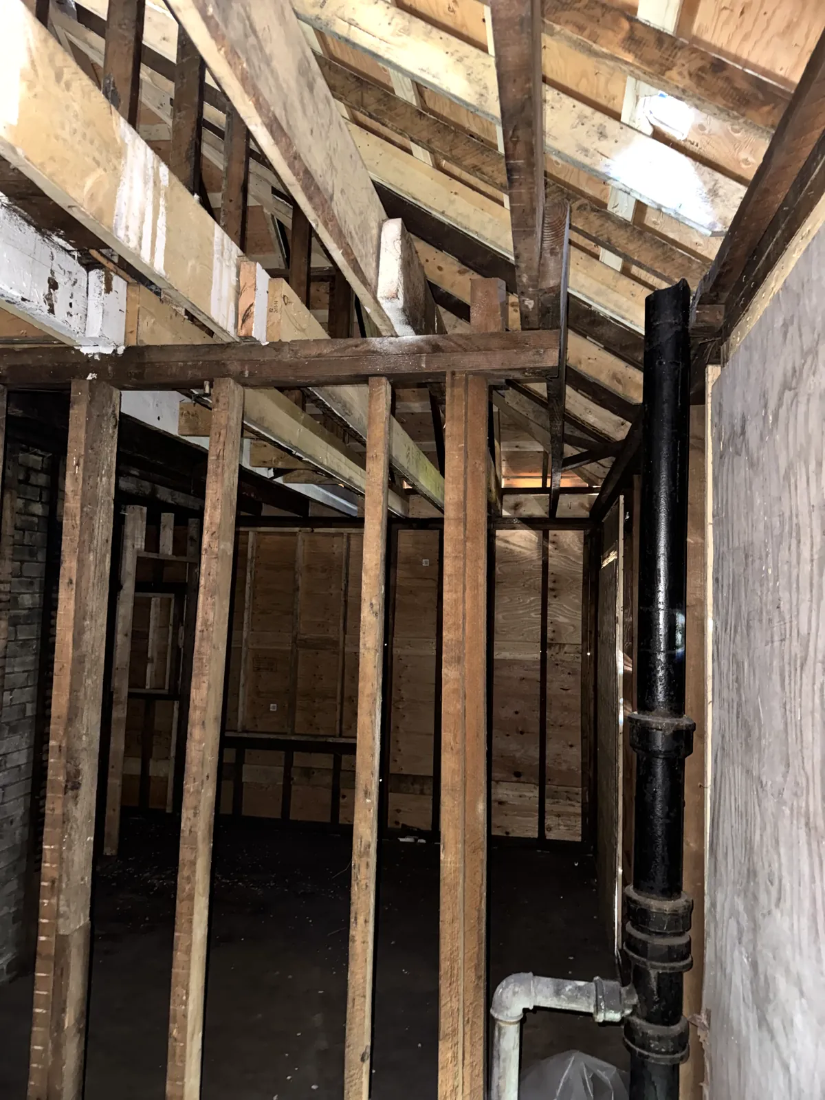Attic framing: new lumber sistered beside charred rafters and studs