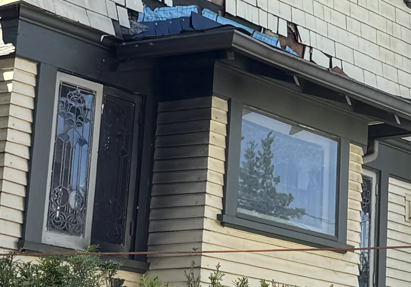 Leaded bay windows that survived below the fire-damaged shingles