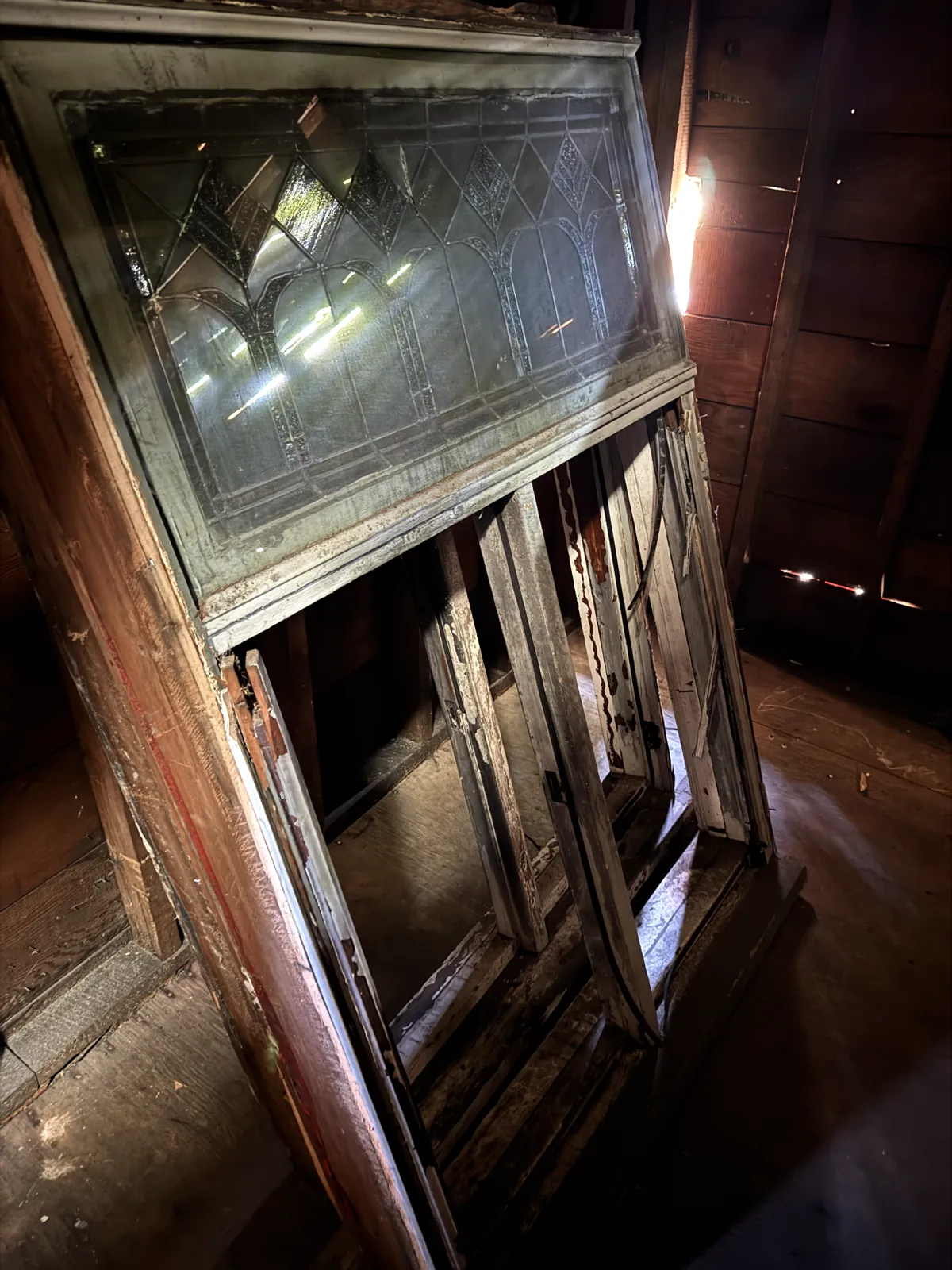 Salvaged leaded art glass sash stored in the attic of a heritage Craftsman after a fire