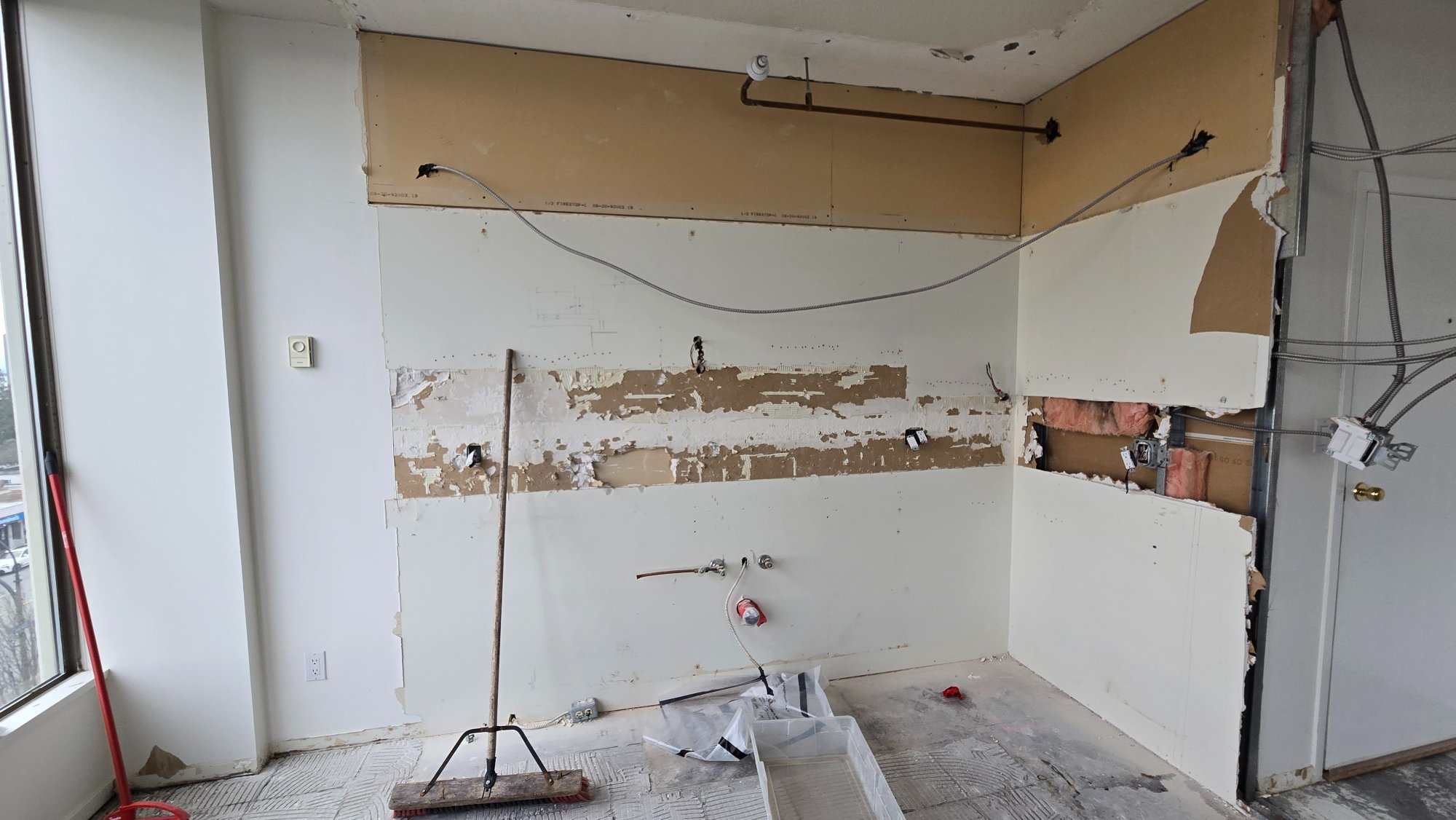 Condo kitchen during demolition — exposed walls and plumbing, ready for rebuild