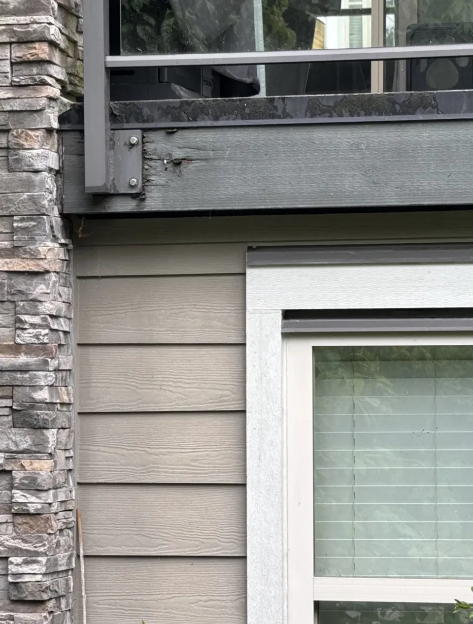 Deck band, stone veneer and siding interfaces on a strata building, the envelope details where balconies meet the wall assembly