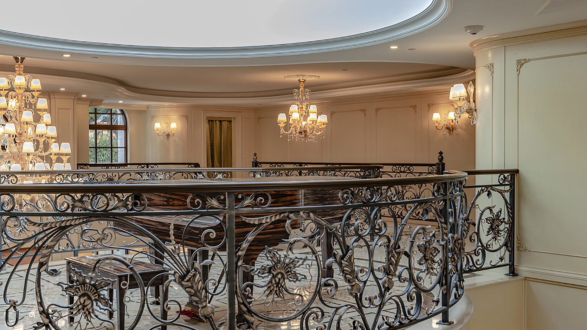 Ambleside Palace upper gallery ironwork detail with crystal chandeliers and coffered ceiling in West Vancouver