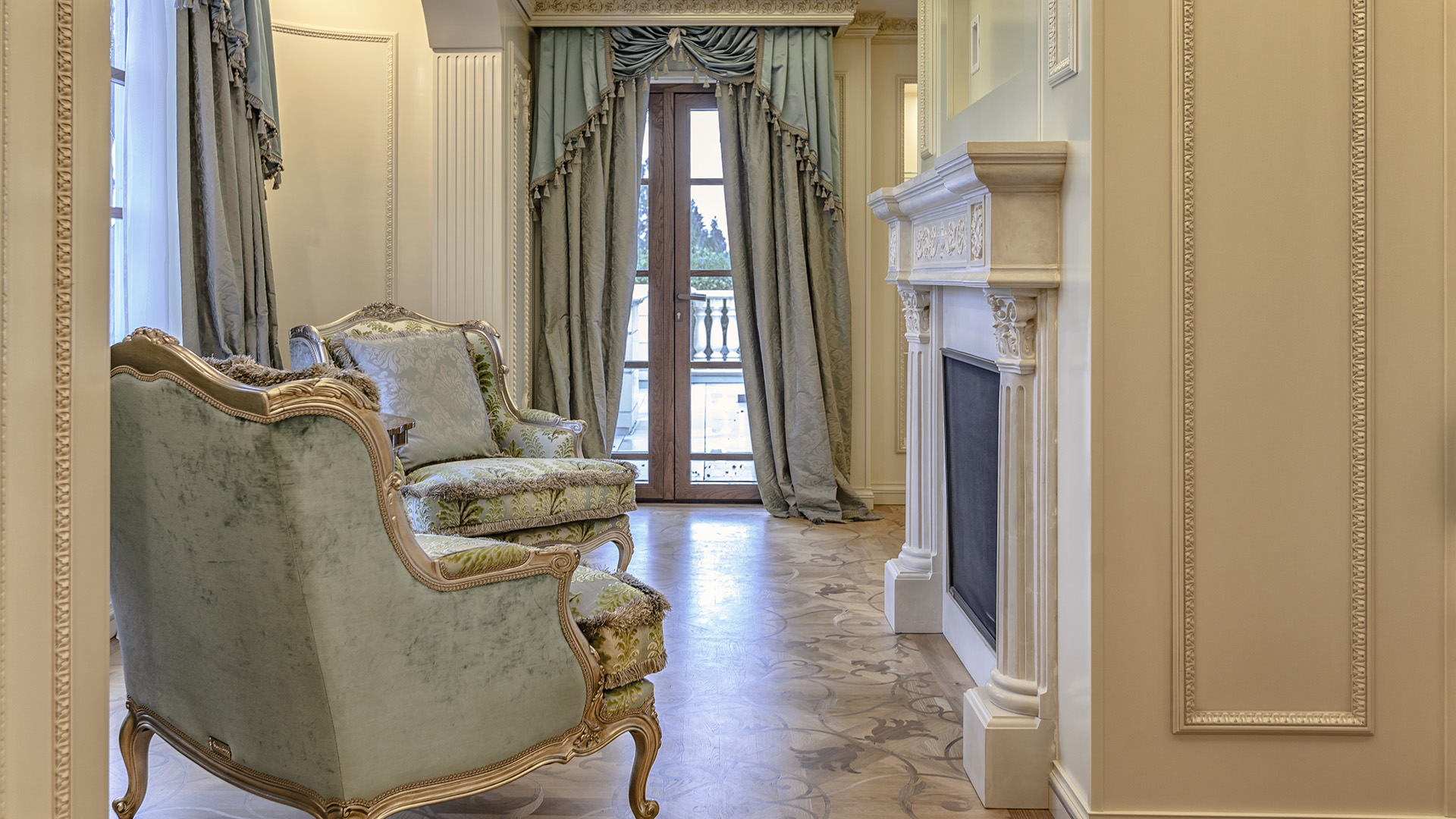 Ambleside Palace master suite sitting area with carved stone fireplace and silk damask armchairs in West Vancouver