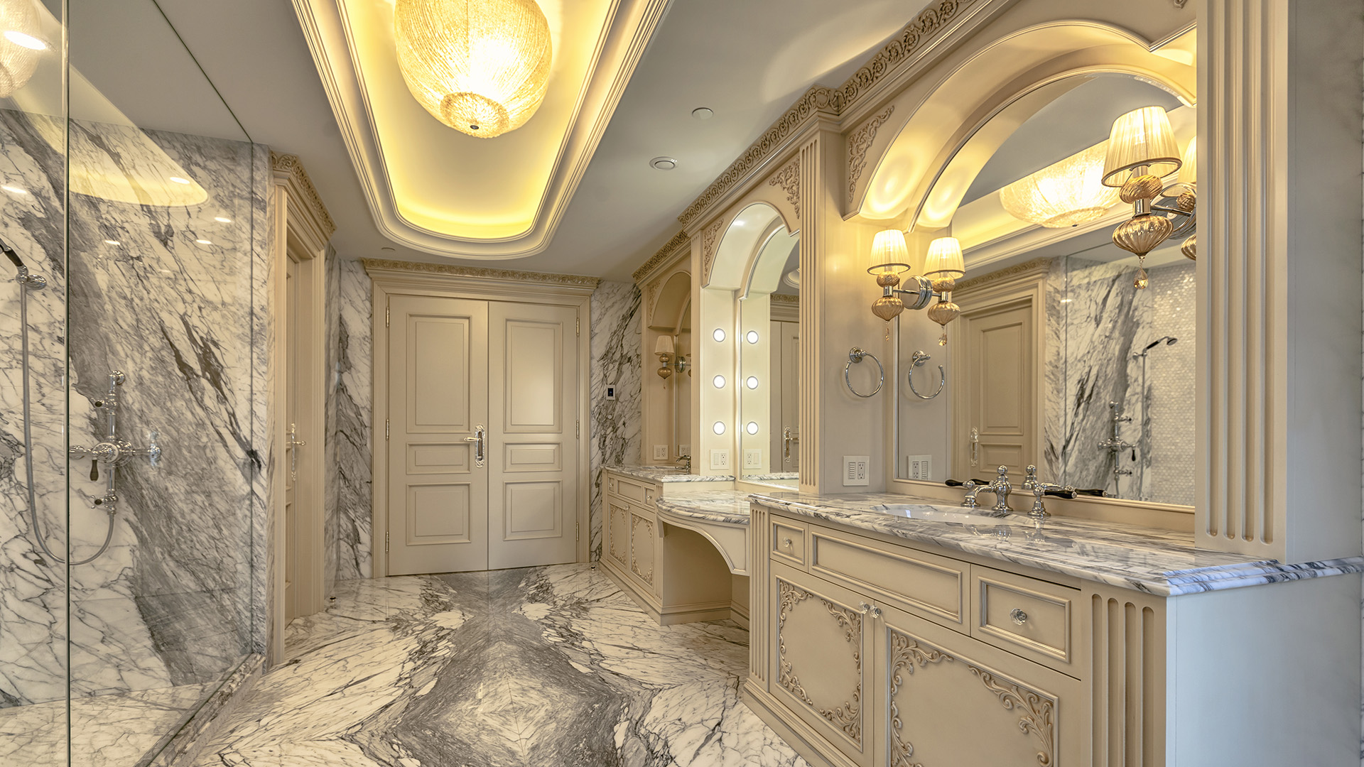 Ambleside Palace master bathroom vanity with marble countertops arched mirrors and custom cabinetry in West Vancouver