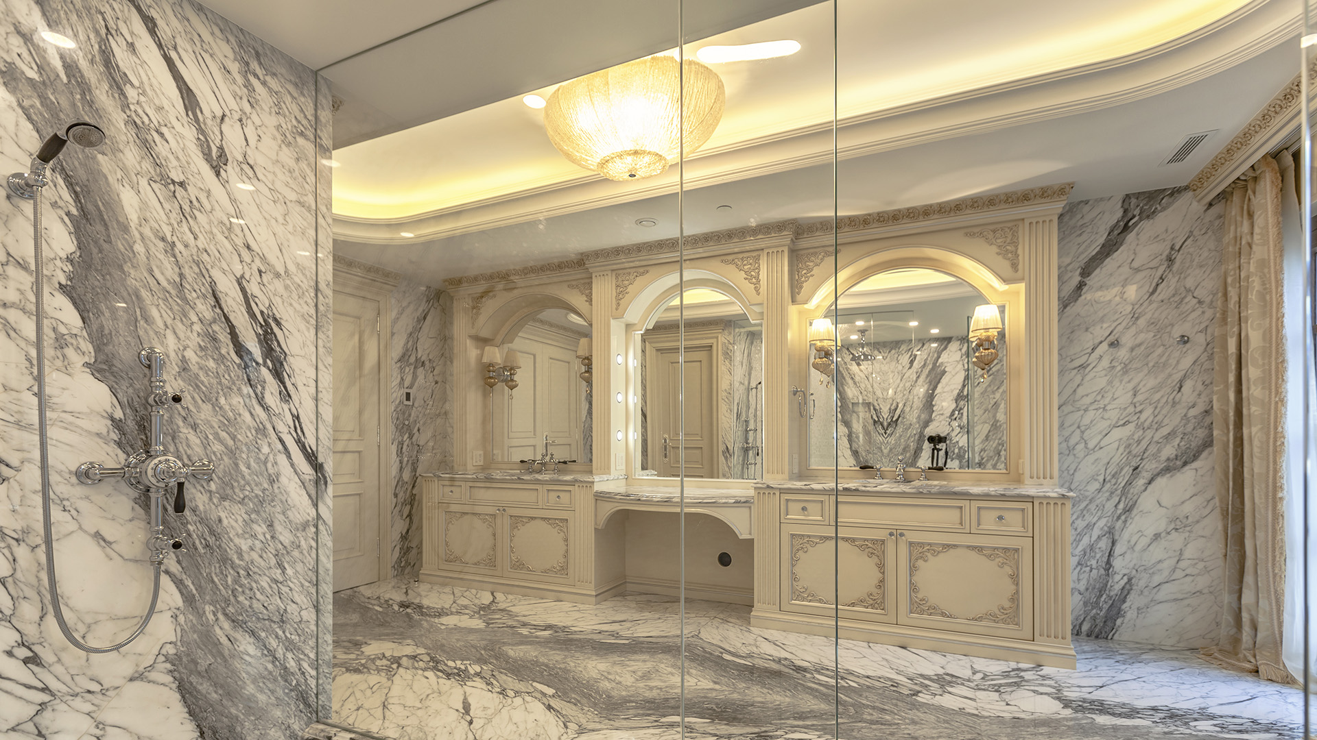 Ambleside Palace master bathroom dual vanity and frameless glass shower enclosure with marble throughout in West Vancouver