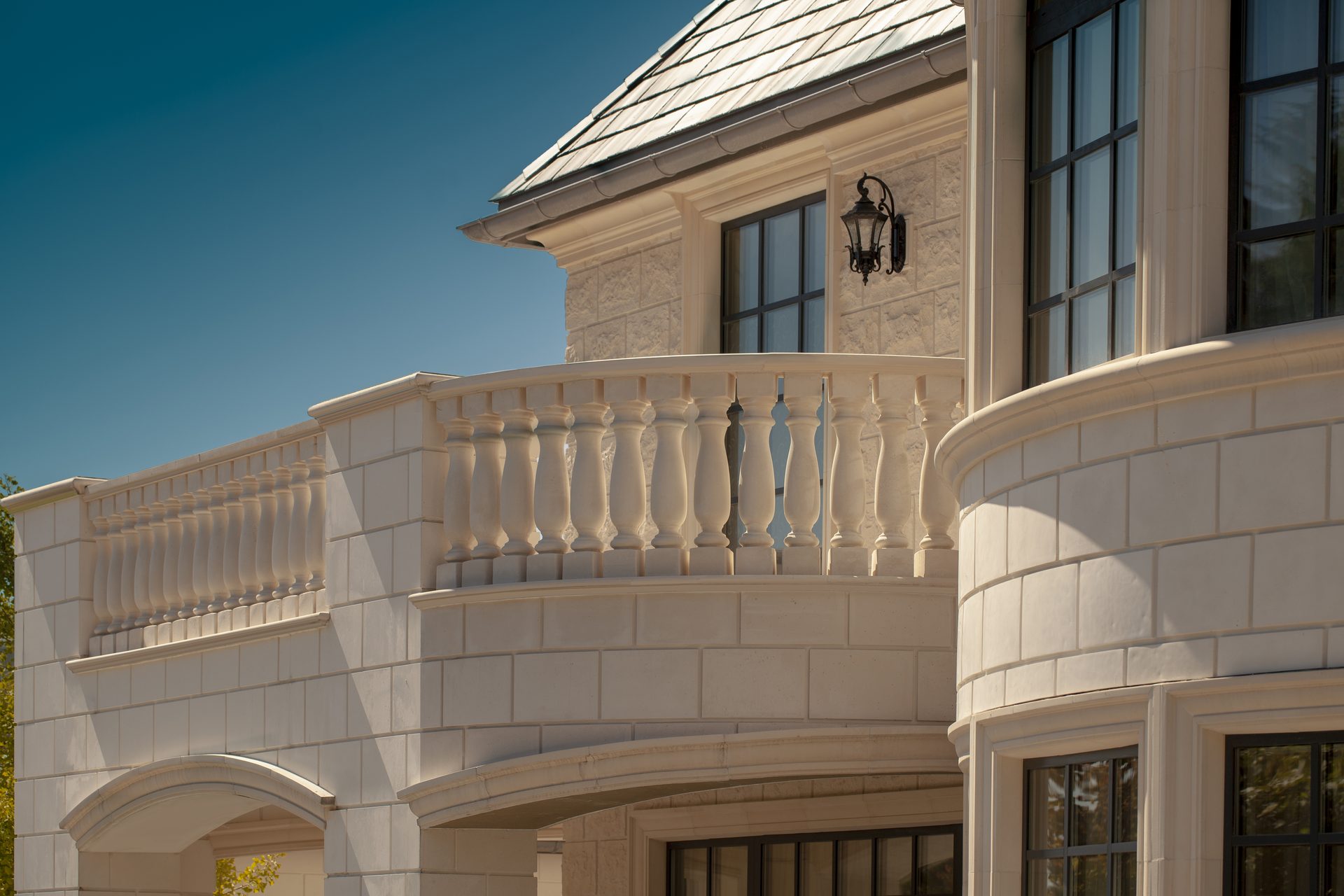 Ambleside Palace curved stone balcony with turned balustrade and wrought iron lantern in West Vancouver