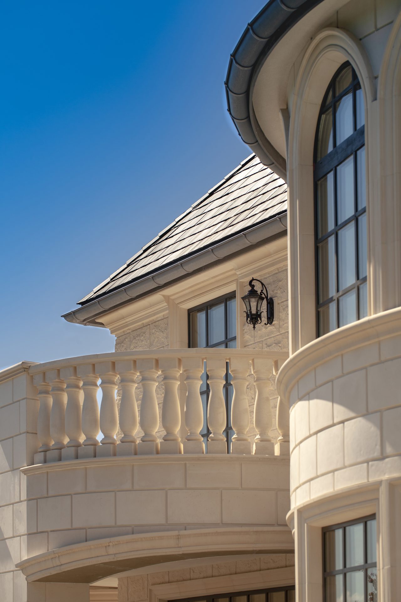 Ambleside Palace curved balcony below slate turret roof with arched leaded window in West Vancouver
