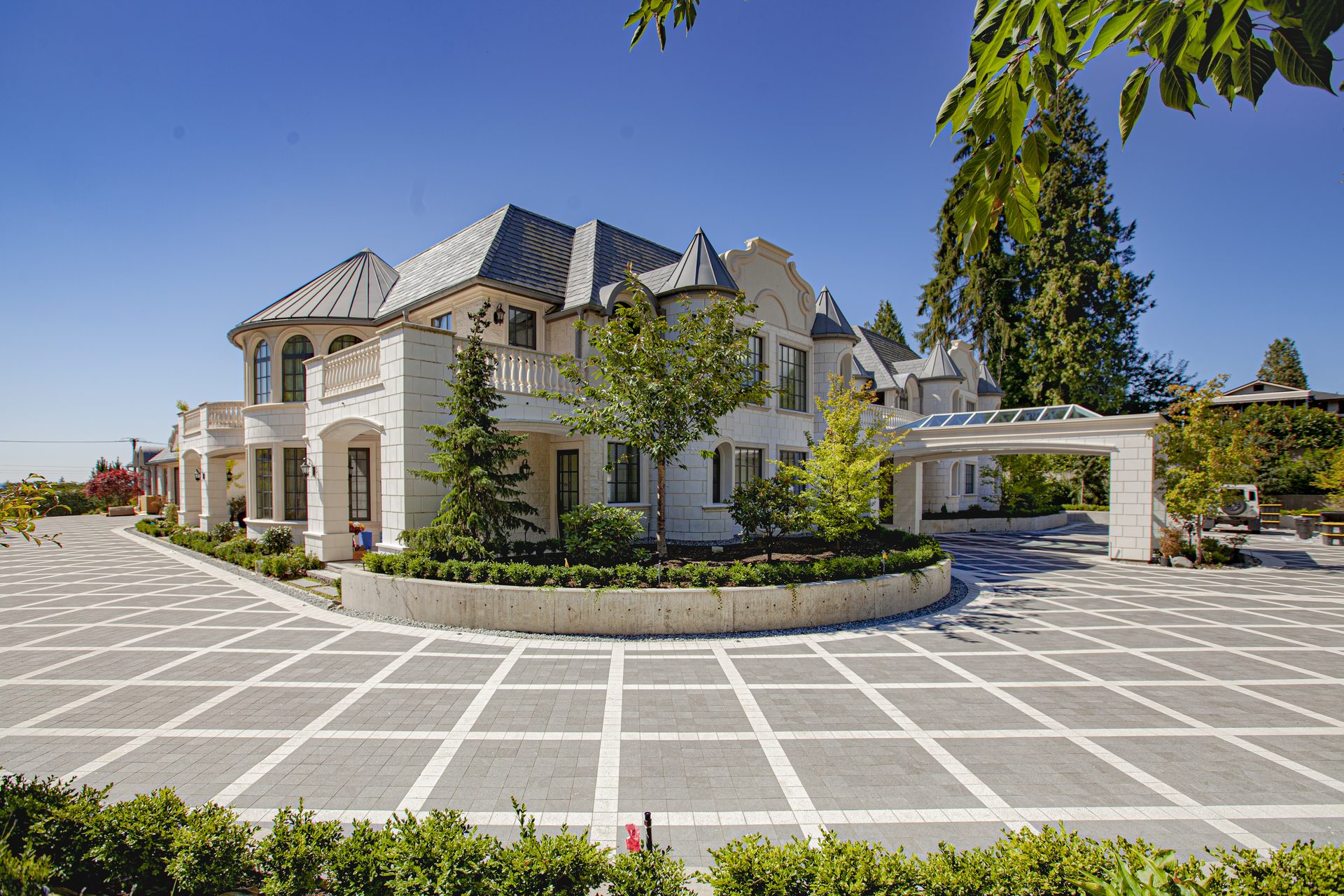 Ambleside Palace front elevation and circular paved motor court with landscaped island in West Vancouver