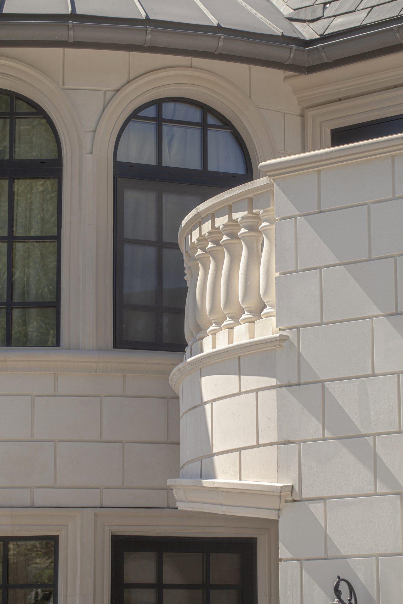 Ambleside Palace close view of carved stone balustrade against arched windows in West Vancouver