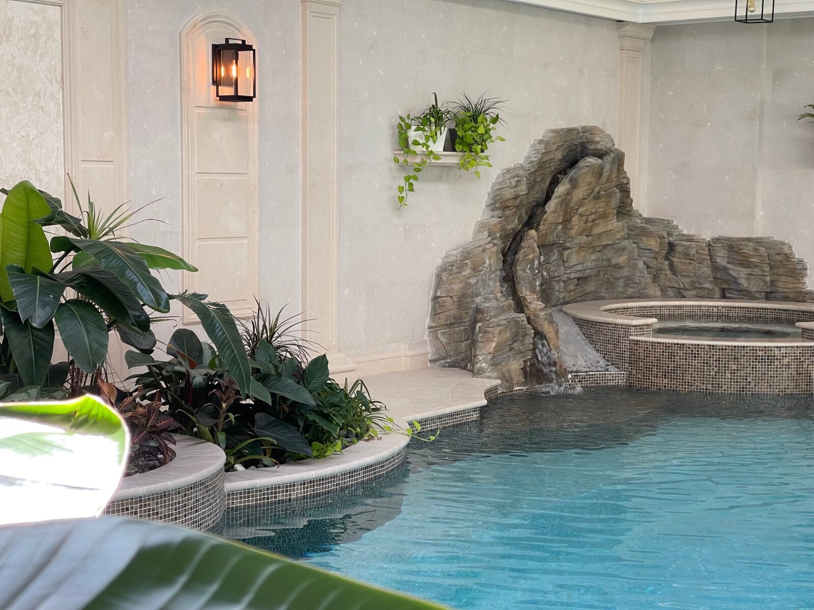 Natural rock grotto hot tub in luxury indoor pool pavilion