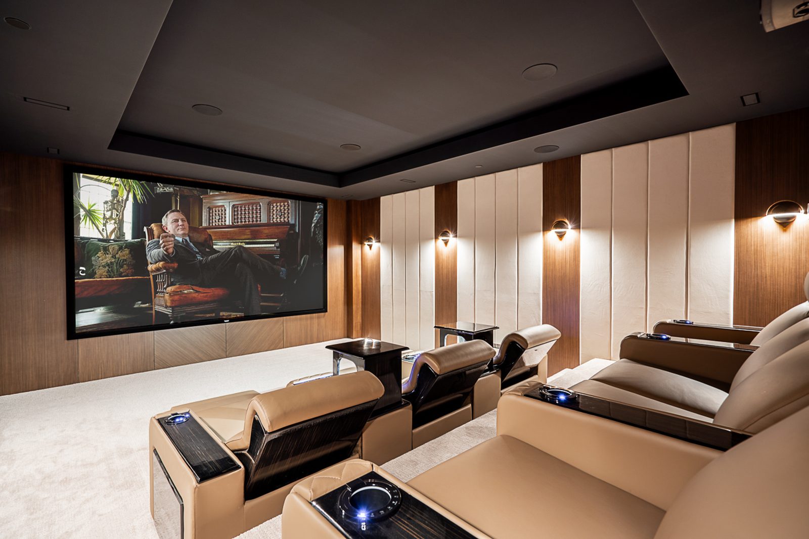 Private home theater with large projection screen leather power recliners and acoustic walnut panels West Vancouver