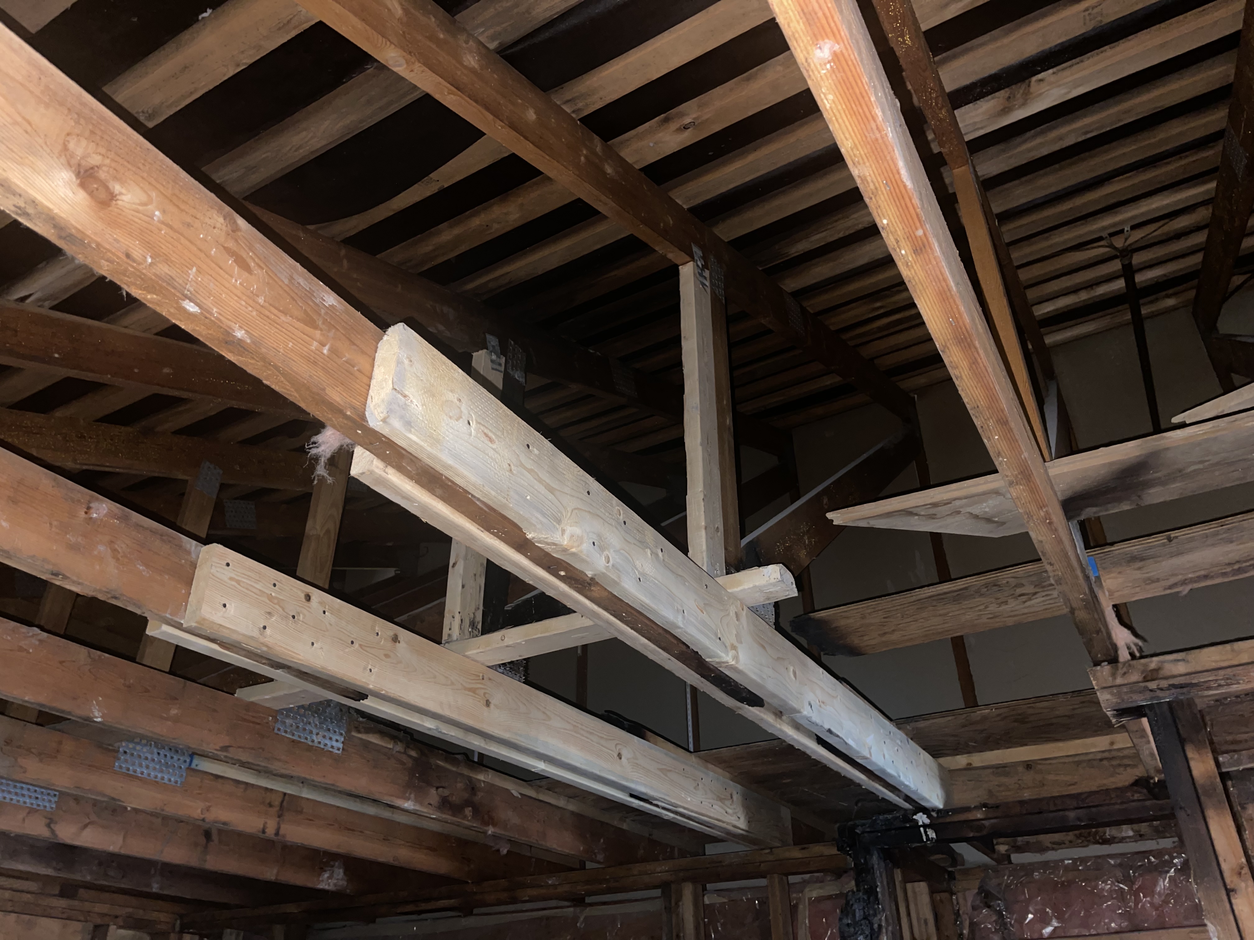 Structural assessment of fire damage showing new framing sistered to damaged joists