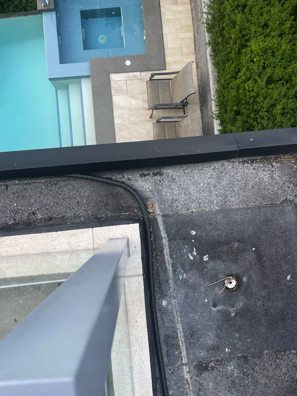 Existing torch-on balcony membrane with drain penetration on a North Vancouver strata deck before replacement