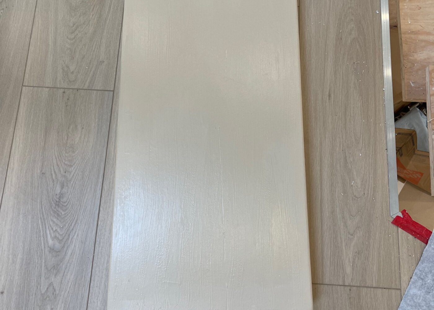 Overhead view of plywood cabinet platform sitting on new laminate flooring allowing natural expansion of floating floor system