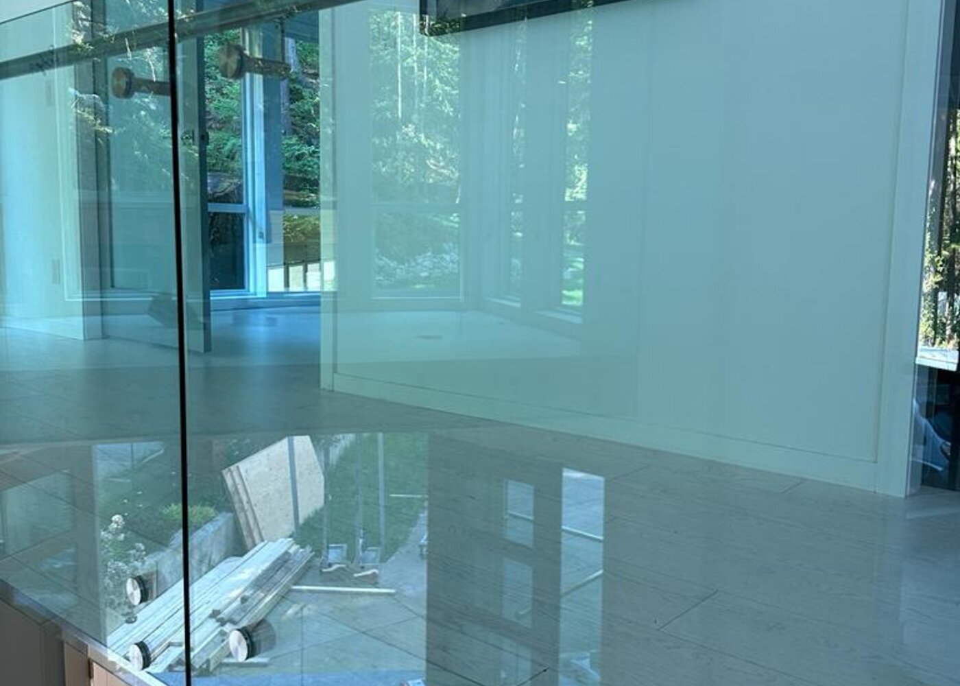 Upper level glass railing with wood flooring before insurance restoration at Prospect Road North Vancouver
