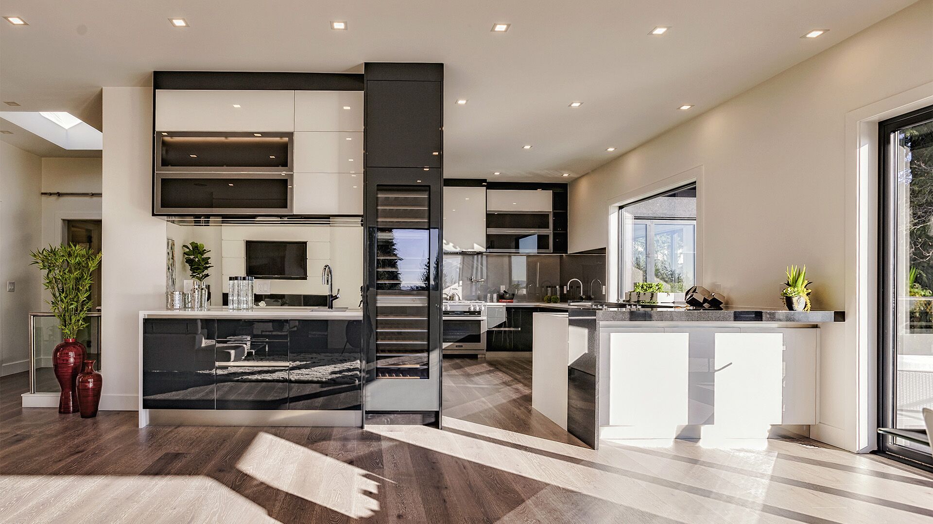 Italian high-gloss black and white lacquer kitchen with integrated wine storage and hardwood flooring, designed and installed by Eurohouse Construction in West Vancouver
