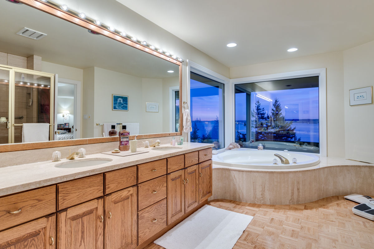 Original master ensuite before renovation with oak vanity cabinetry corner soaking tub parquet flooring and ocean views through corner window at Rockridge Classic before Eurohouse Construction renovation