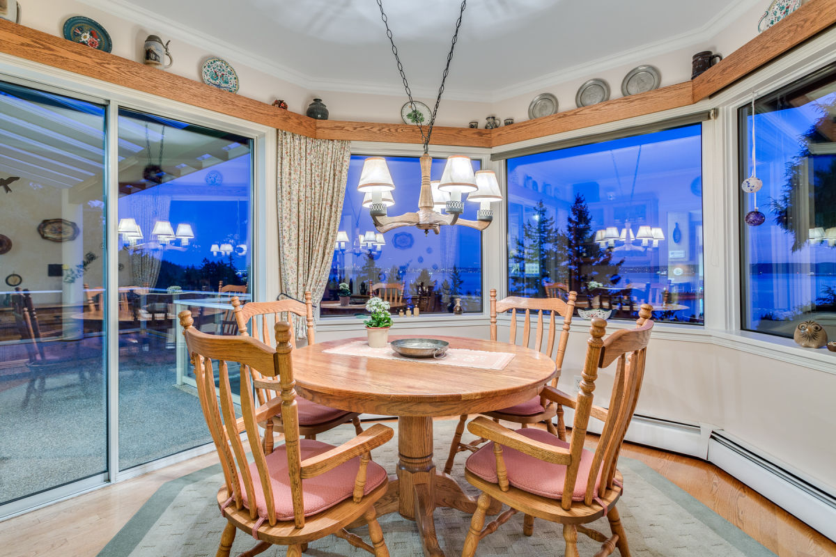 Original kitchen alternate angle showing oak cabinets dishwasher patterned tile backsplash and breakfast nook with oak dining set visible beyond at Rockridge Classic before Eurohouse Construction renovation