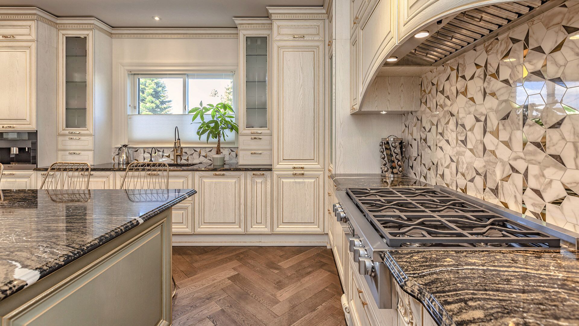 Working angle of Italian classical kitchen with herringbone oak floors, granite countertops, and geometric gold-marble backsplash by Eurohouse Construction