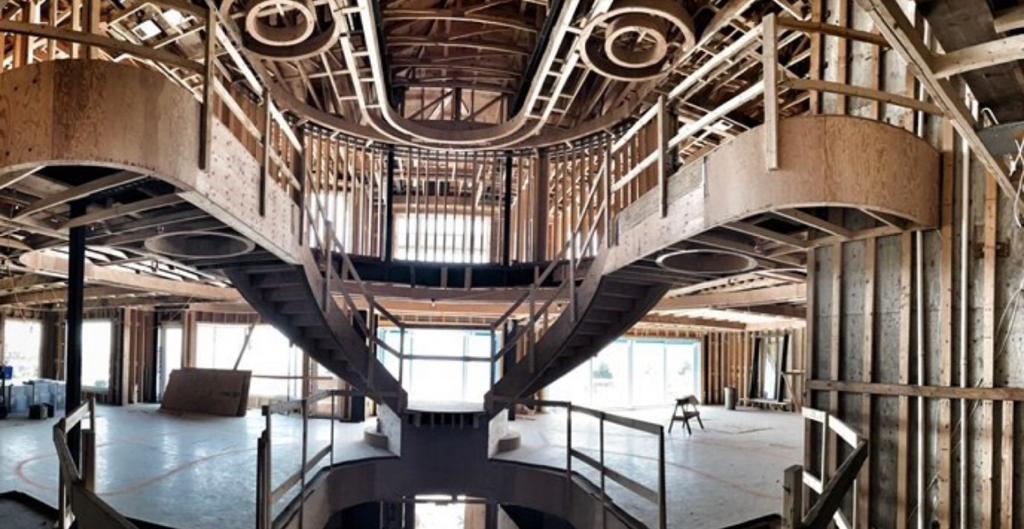 Panoramic view of curved structural framing and steel staircase during construction of The H House luxury estate — high-complexity residential build by Eurohouse Construction