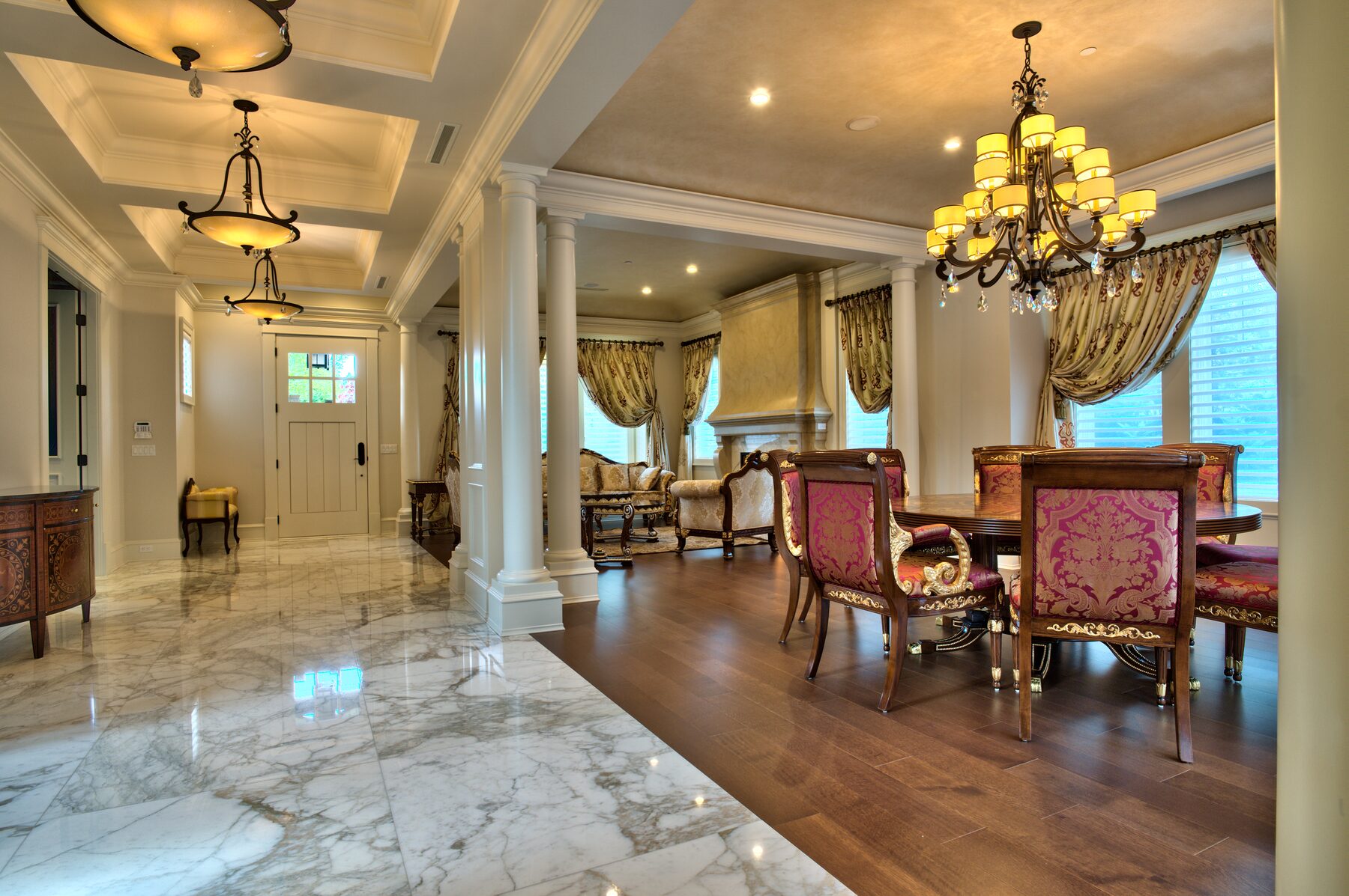 View from a marble entry hall through columns to a dining room furnished with Francesco Molon Italian furniture in a Vancouver home furnished by Eurohouse Construction