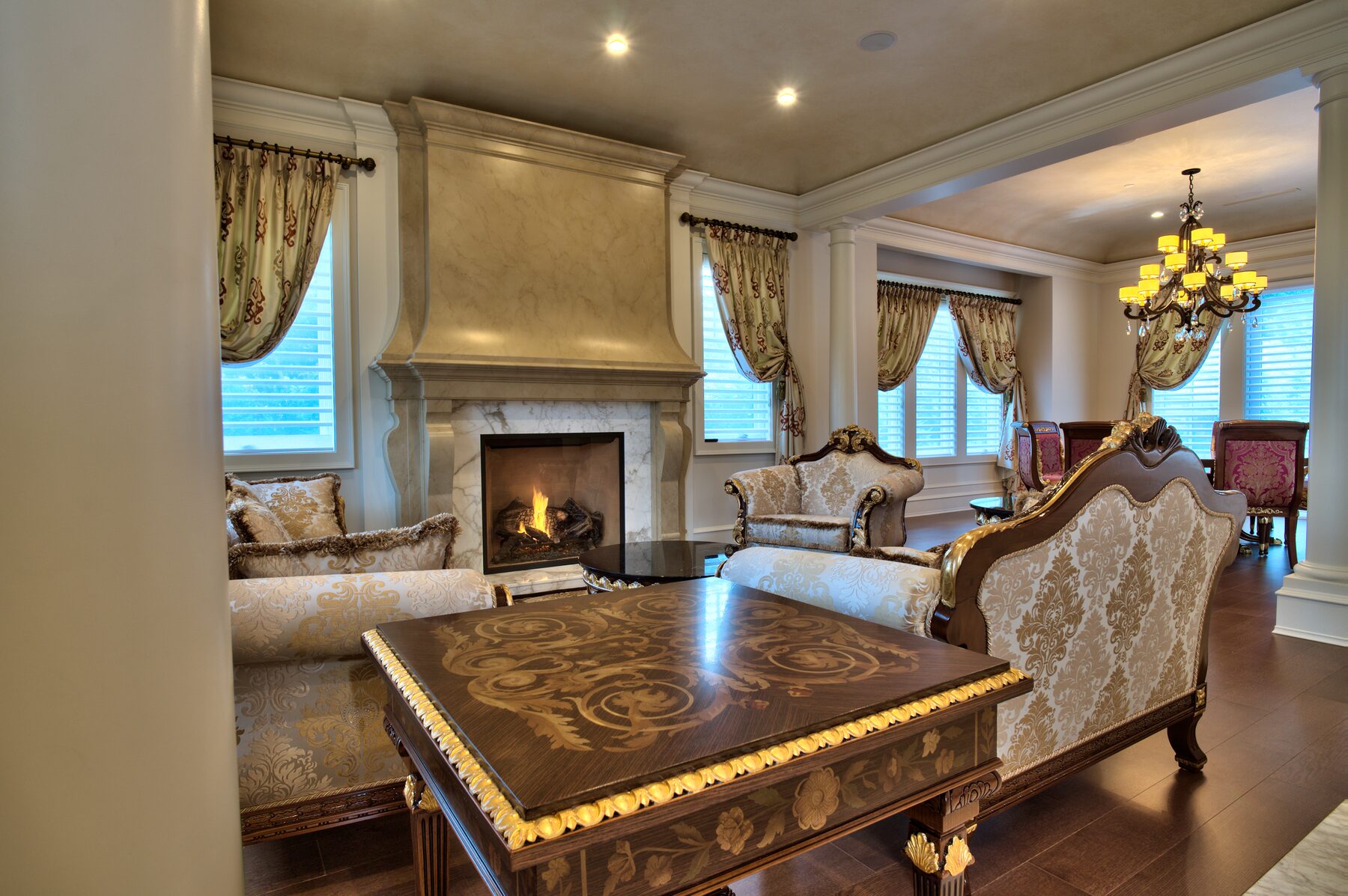 Rectangular Francesco Molon coffee table with gold leaf inlaid top and carved gilded legs in a Vancouver living room furnished by Eurohouse Construction