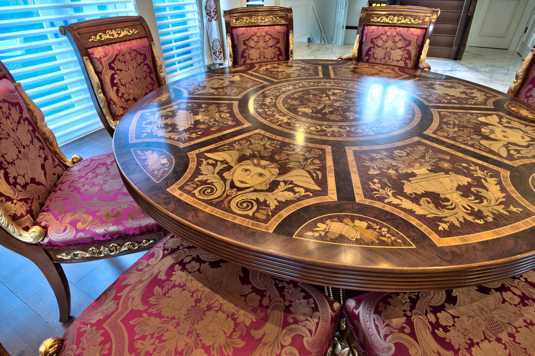 Close view of a round Francesco Molon dining table top with radial marquetry inlay in multiple wood tones, Italian furniture supplied by Eurohouse Construction in Vancouver