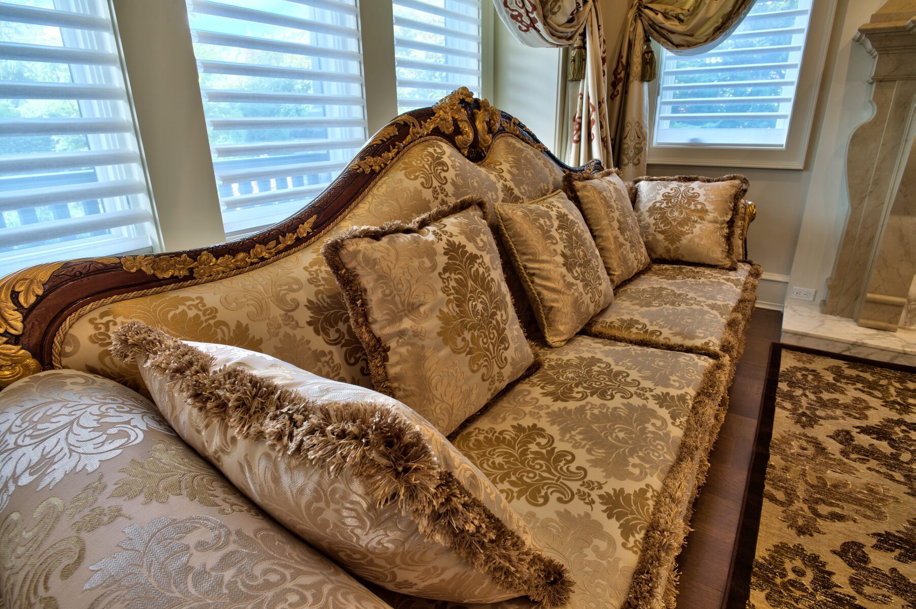 Close view of a carved Francesco Molon sofa in cream and gold silk damask with matching cushions in a Vancouver home furnished by Eurohouse Construction