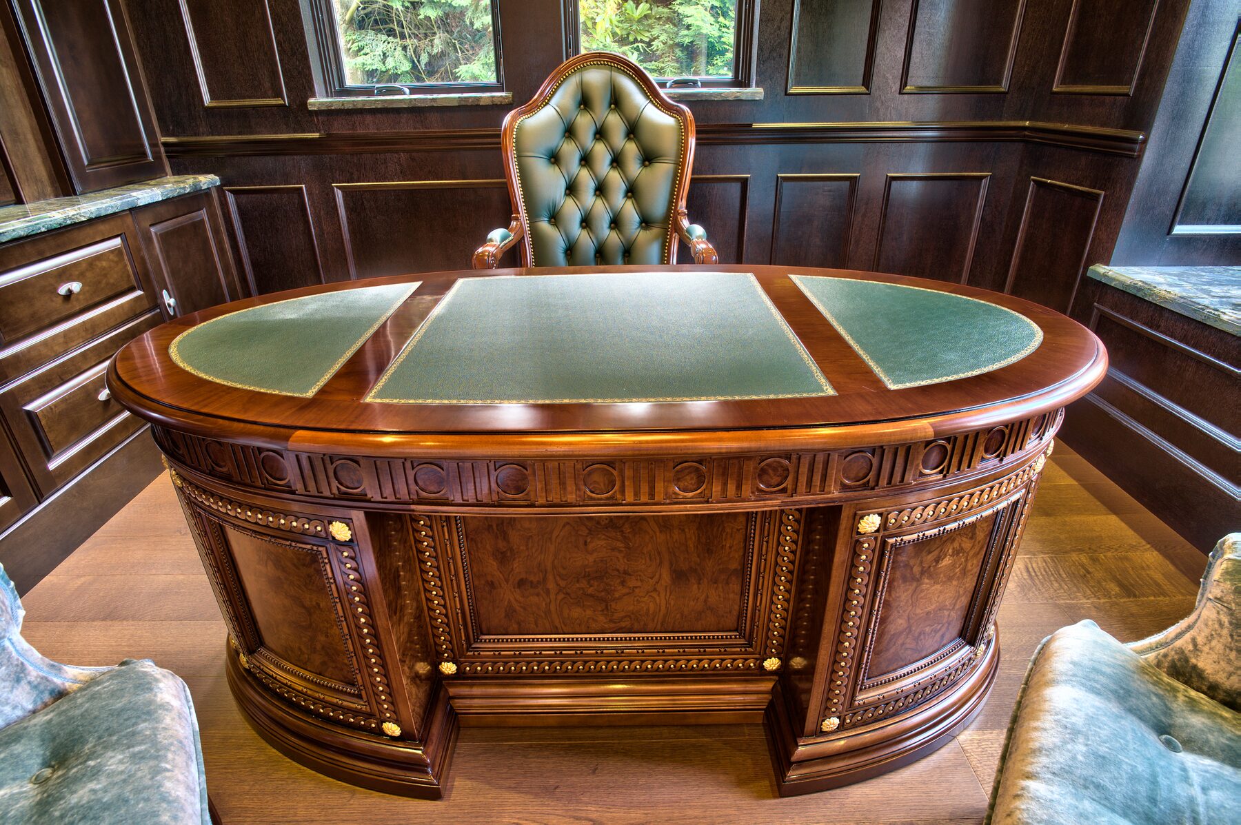 Francesco Molon bowfront pedestal desk with inlaid banding, inset leather writing top, and tufted high back chair in a panelled Vancouver study furnished by Eurohouse Construction