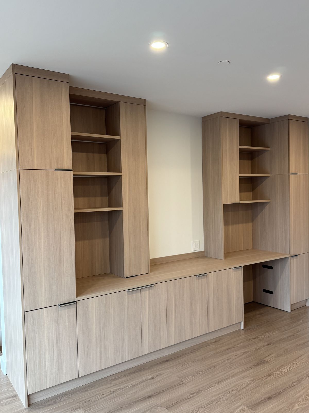 Custom entertainment and desk wall unit in walnut laminate with open shelving — insurance restoration millwork