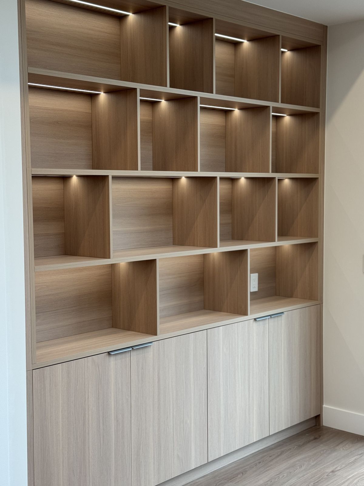 Custom built-in bookshelf with LED accent lighting and walnut cabinetry — fire restoration interior finishing
