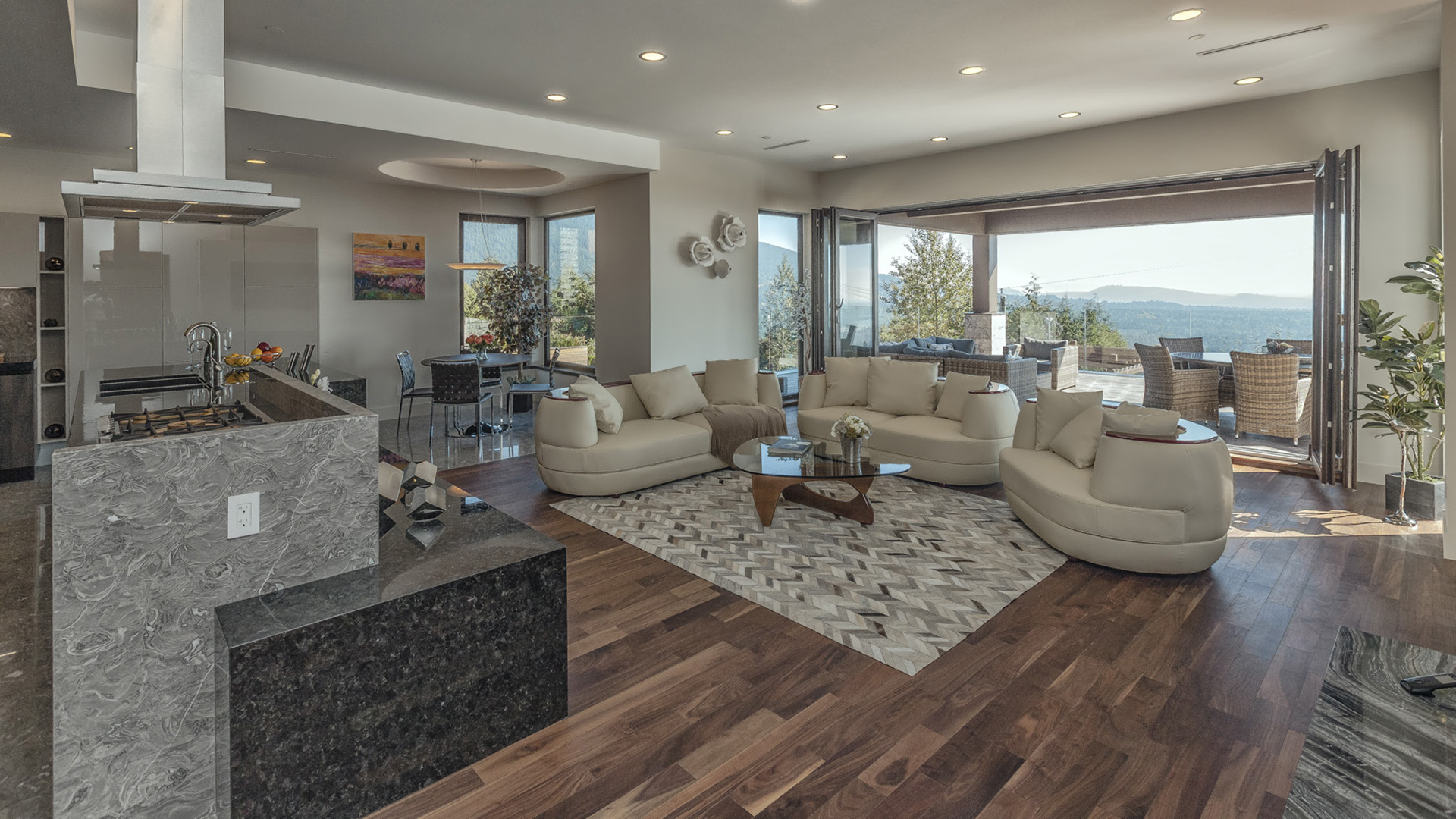 Open-plan main floor living with 10ft ceilings premium walnut flooring granite kitchen island folding eclipse doors and panoramic views West Coast Contemporary British Properties West Vancouver