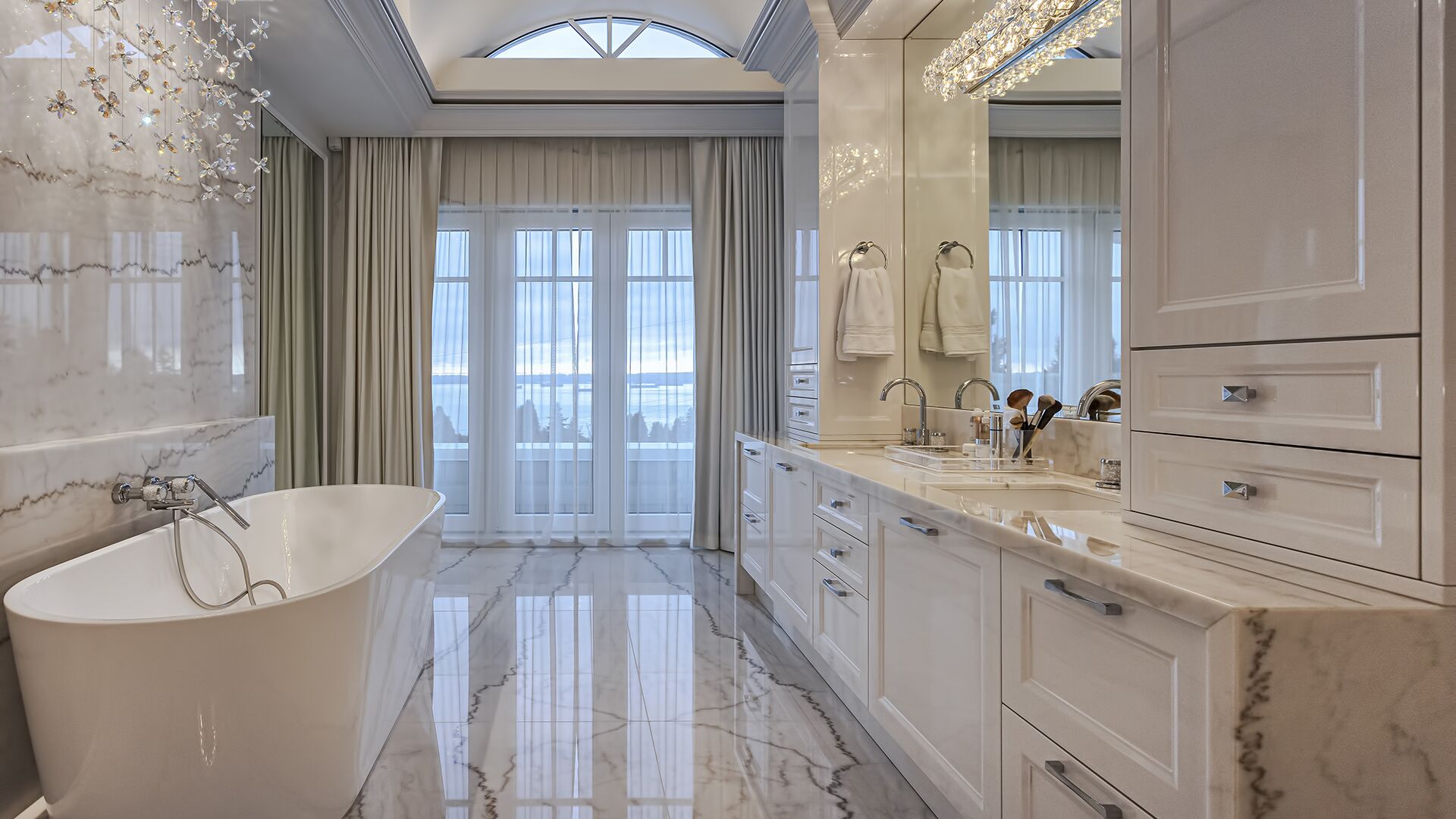 Master ensuite spa bathroom with freestanding soaker tub crystal chandelier marble floors and ocean views luxury West Vancouver home by Eurohouse Construction