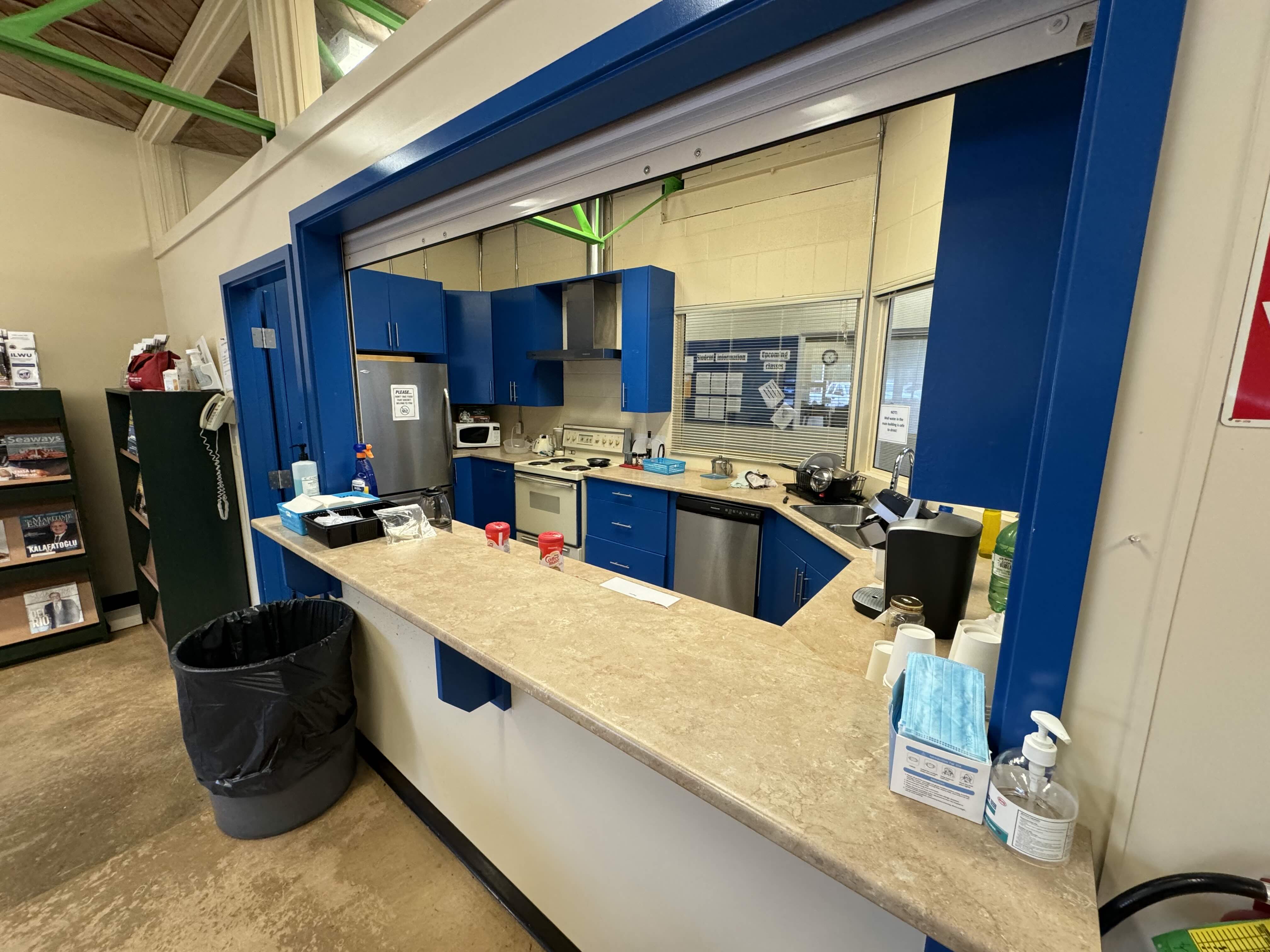 Original kitchen area with dated cabinetry and countertops at Western Maritime Institute